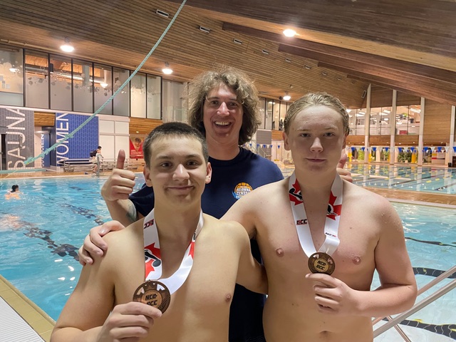 <who> Photo Credit: Contributed</who> Octavio and Mason with Kelowna Water Polo Club’s senior youth coach Adam Frank after their bronze medal win.
