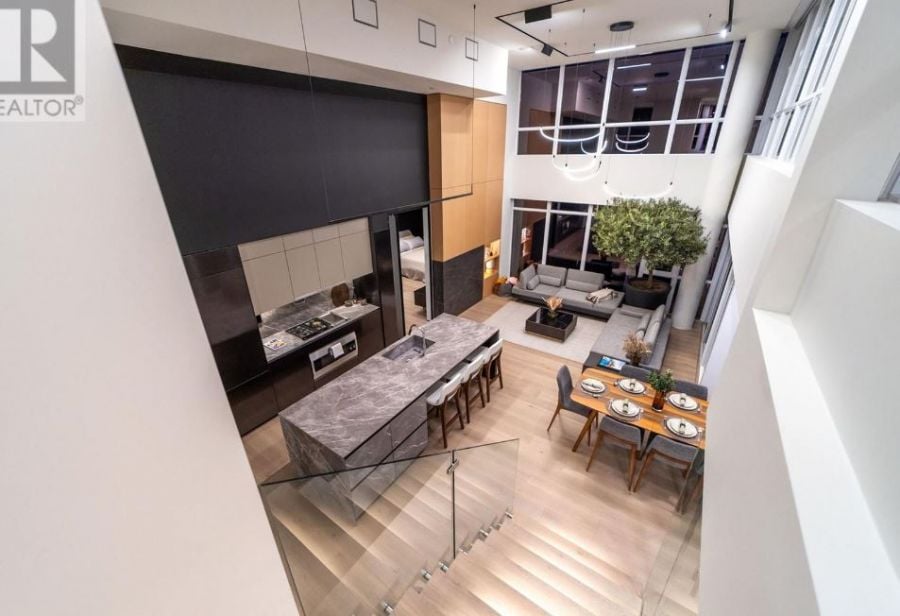 </who>The open-concept living room, dining room and kitchen pictured from the top of the floating stairs. Below, the view of the great space from another angle.