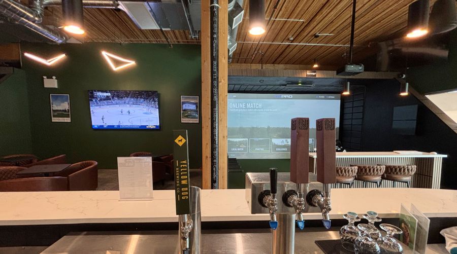 <who>Photo Credit: KelownaNow</who>The other side of OVG Kelowna with some local beers on tap and the lounge area. Not seen is the 4th golf simulator bay to the left.