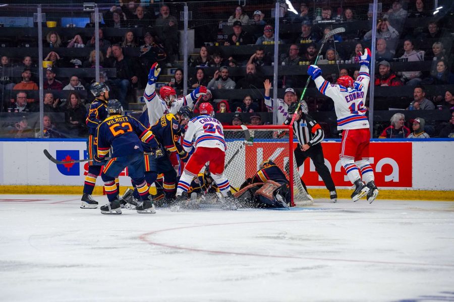 <who>Photo Credit: Kitchener Rangers/Facebook</who>Sam O'Reilly (L), Gabriel Chariot (C) and Dylan Edwards (R) celebrate Chariot's overtime winner in game 3 of the OHL final.